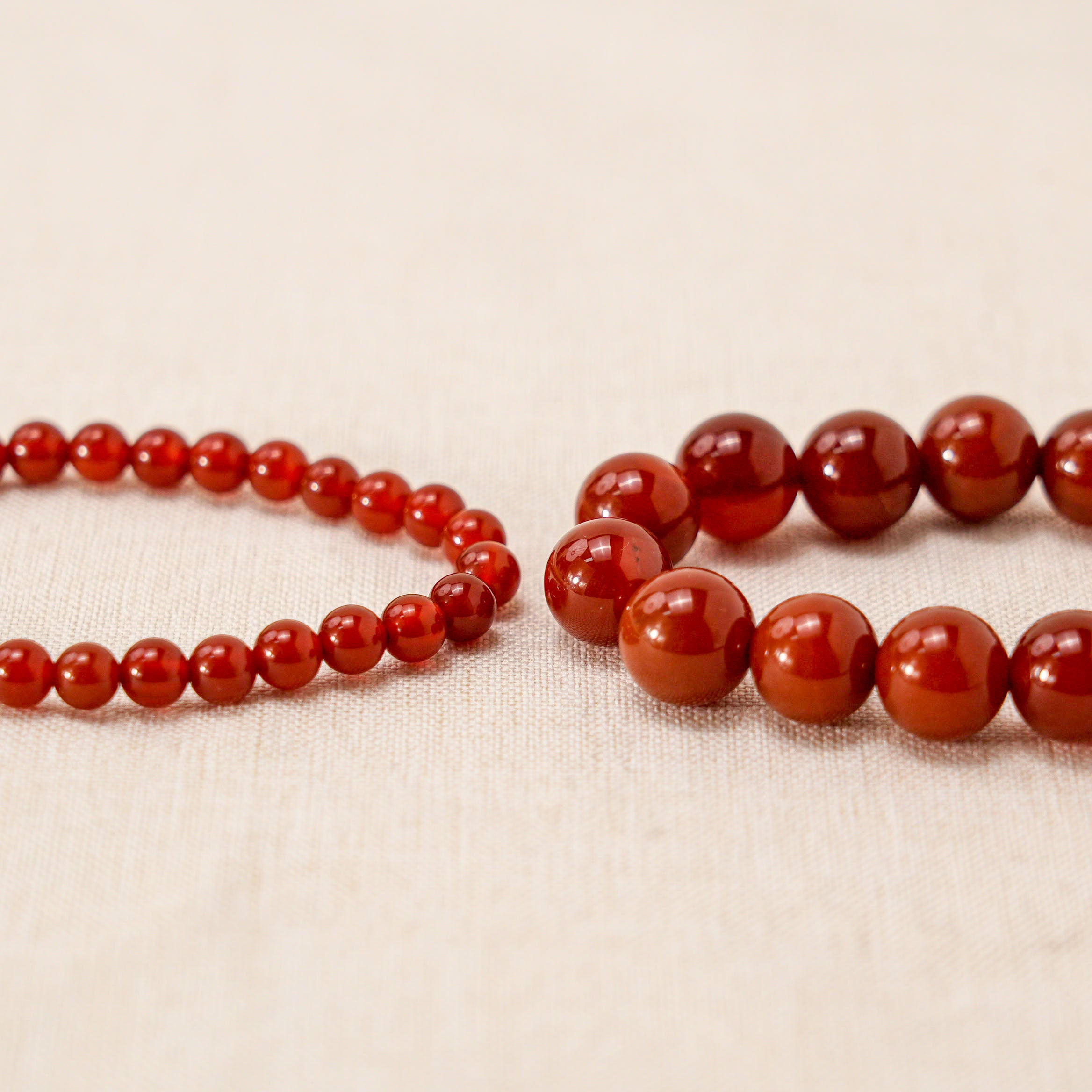 two different bead size carnelian bracelets close up plane view