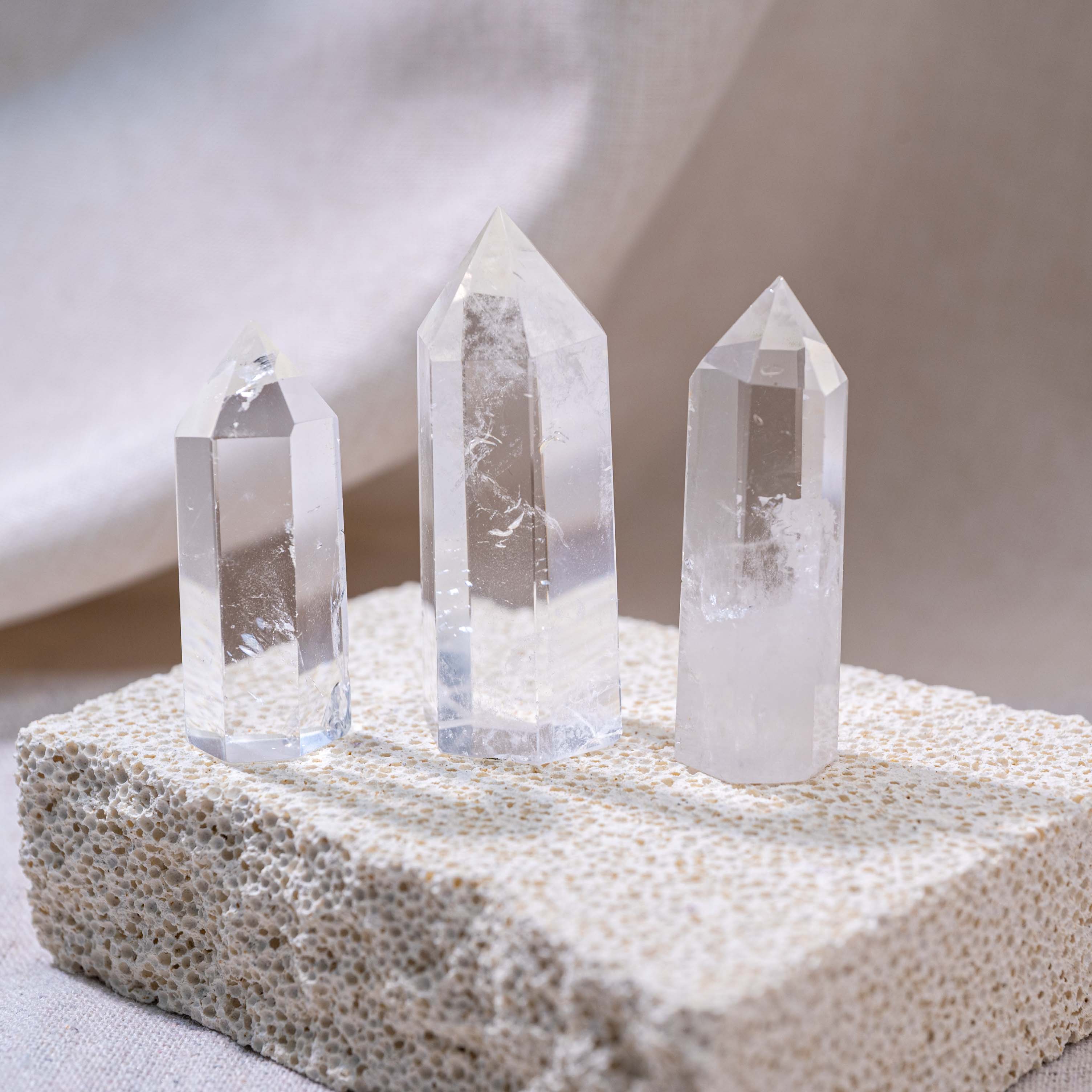 three clear quartz point towers stand on a rock