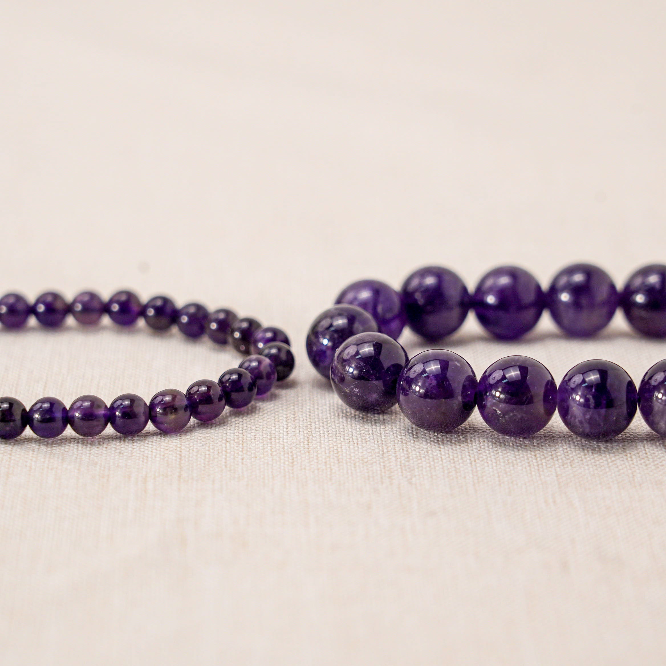 two different bead size amethyst bracelets close up plane view