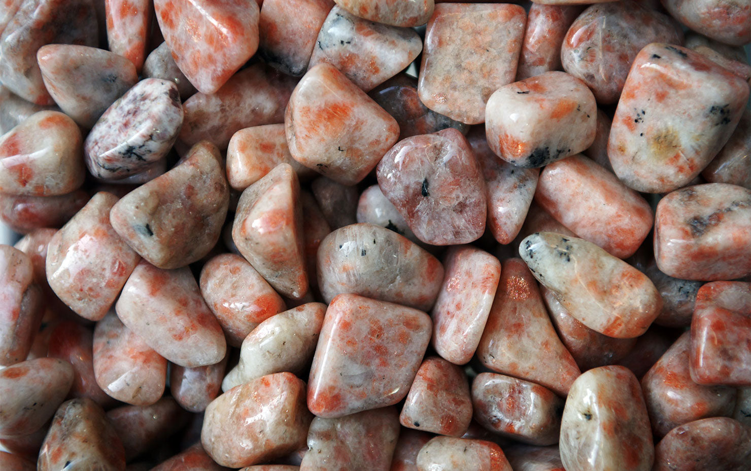 A shimmering Sunstone gemstone with warm orange and golden hues reflecting light beautifully