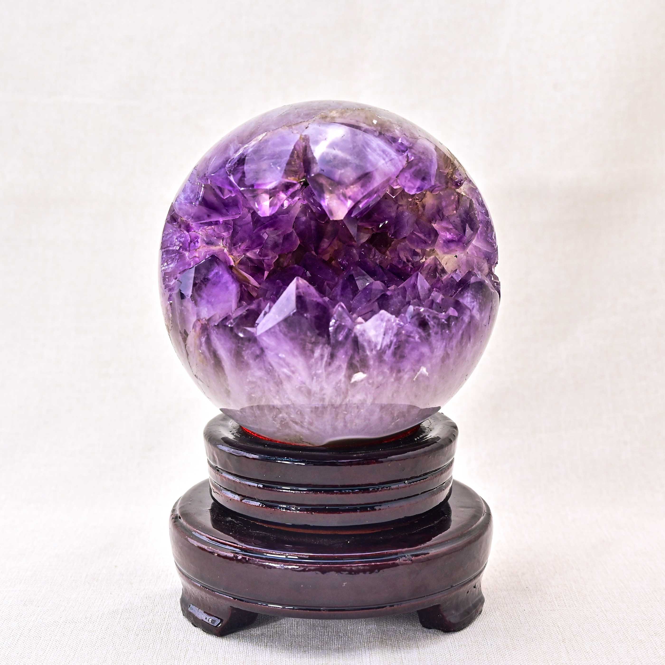 Natural amethyst cluster sphere with deep purple hues and intricate crystal formations