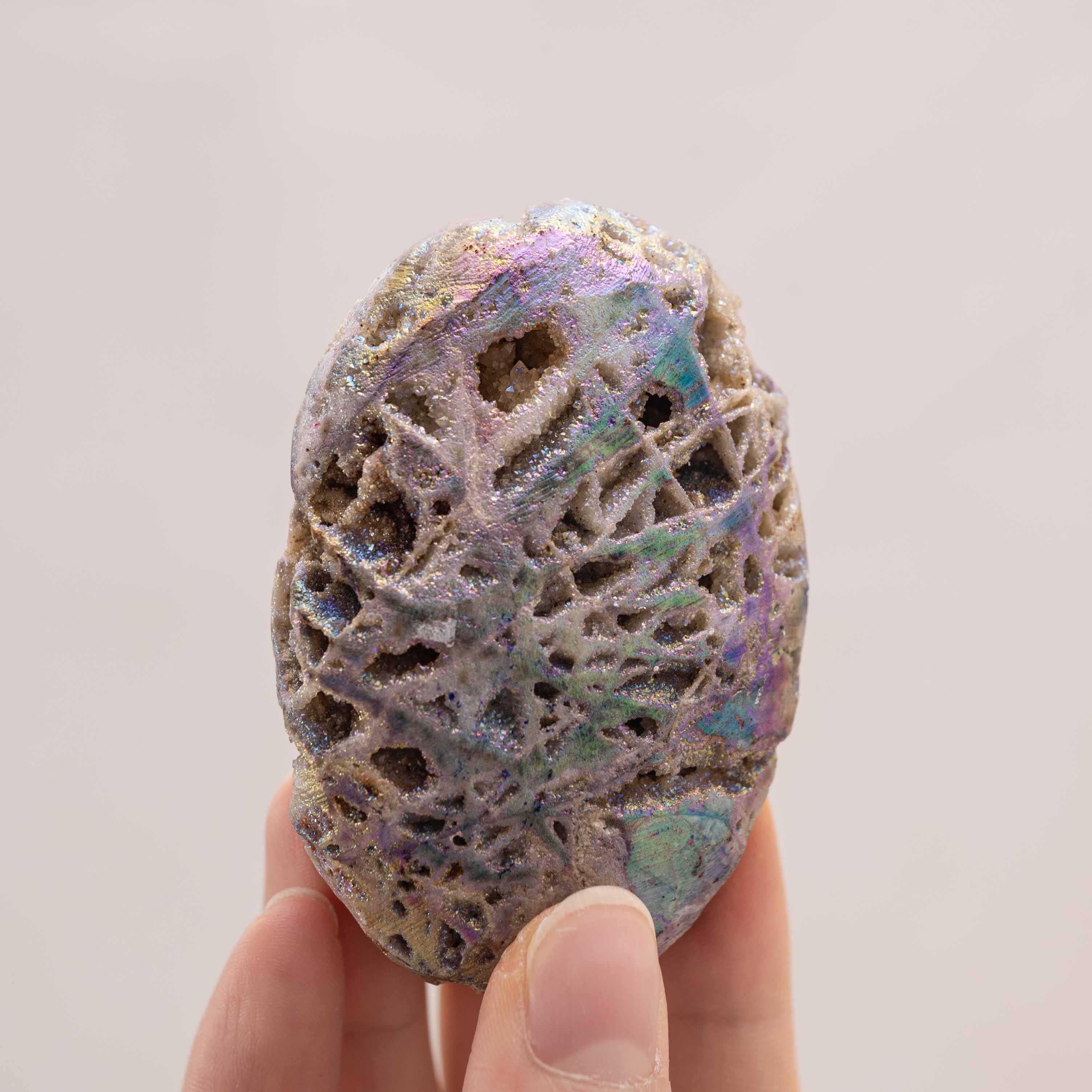 Hand-held Aura Sphalerite crystal, showcasing its unique multicolored iridescence