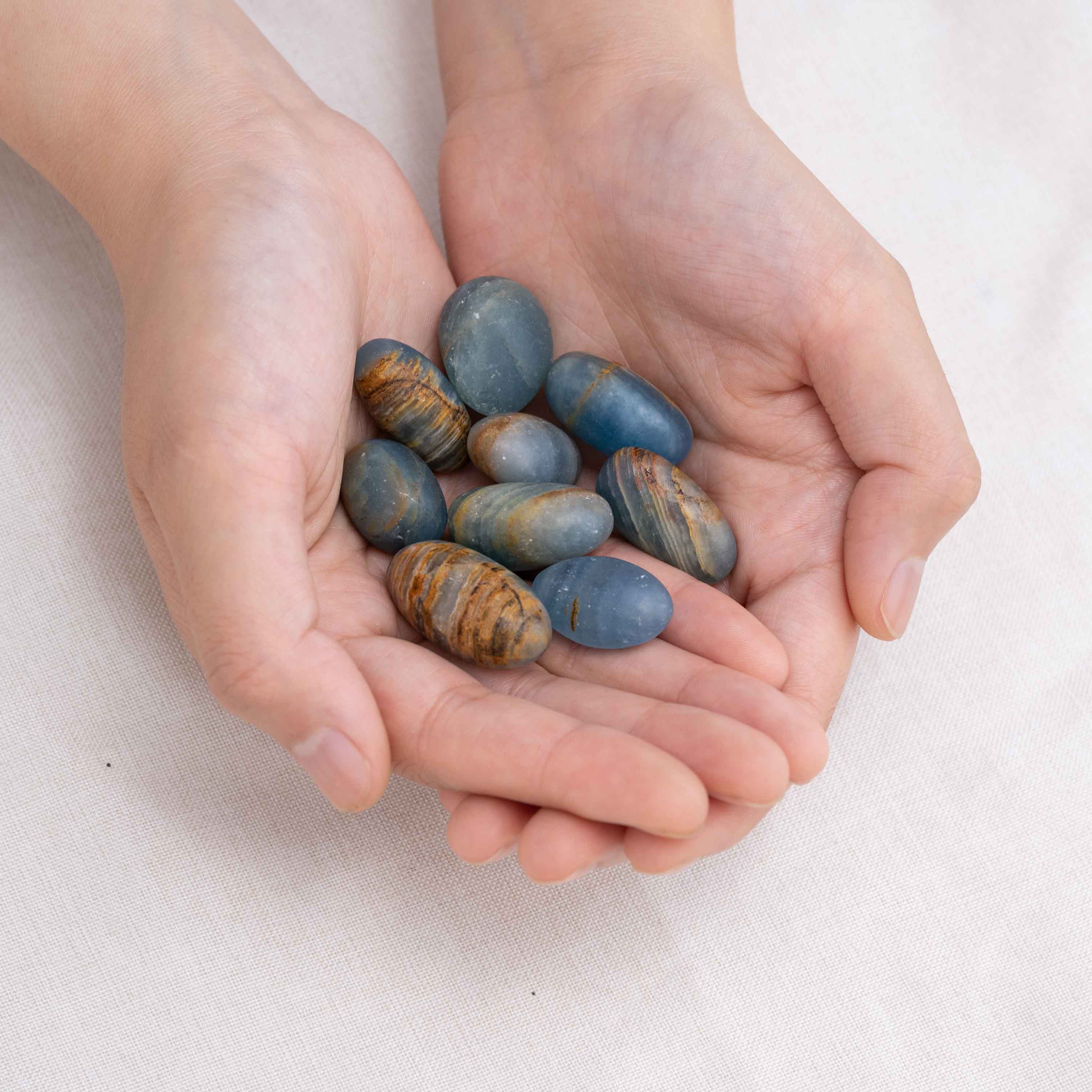 Hand cupping Blue Onyx tumbled stone for protection and grounding