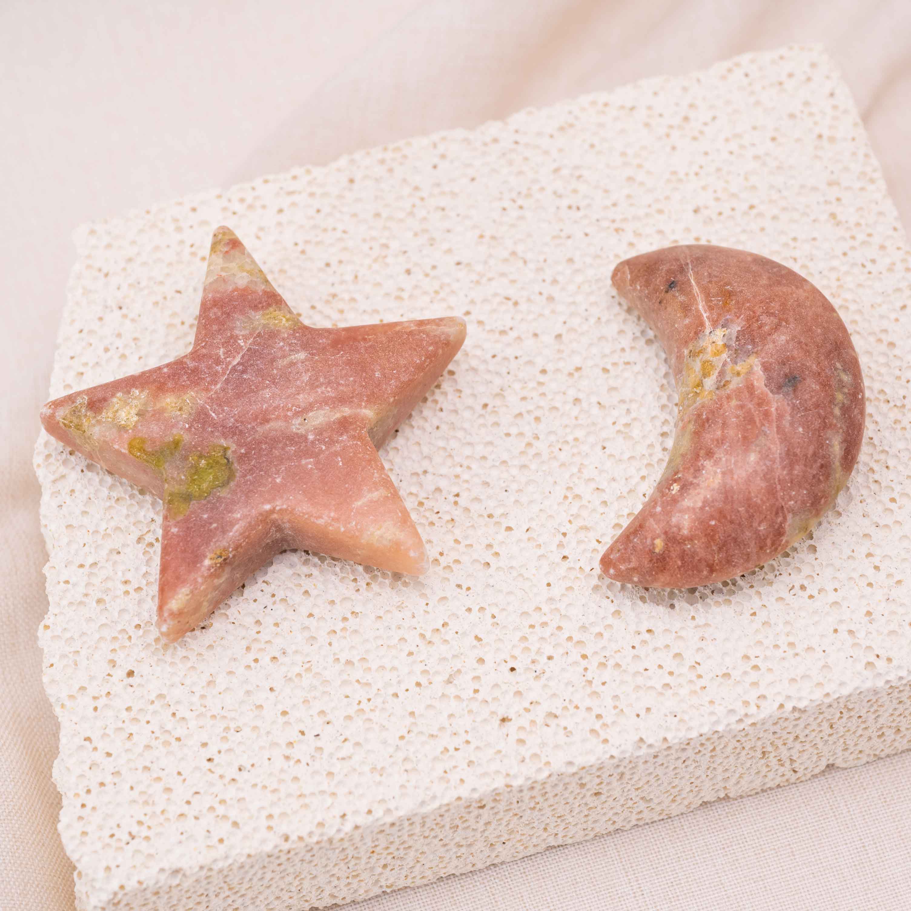 Display of Pink Serpentine Star/Moon Palm Stone