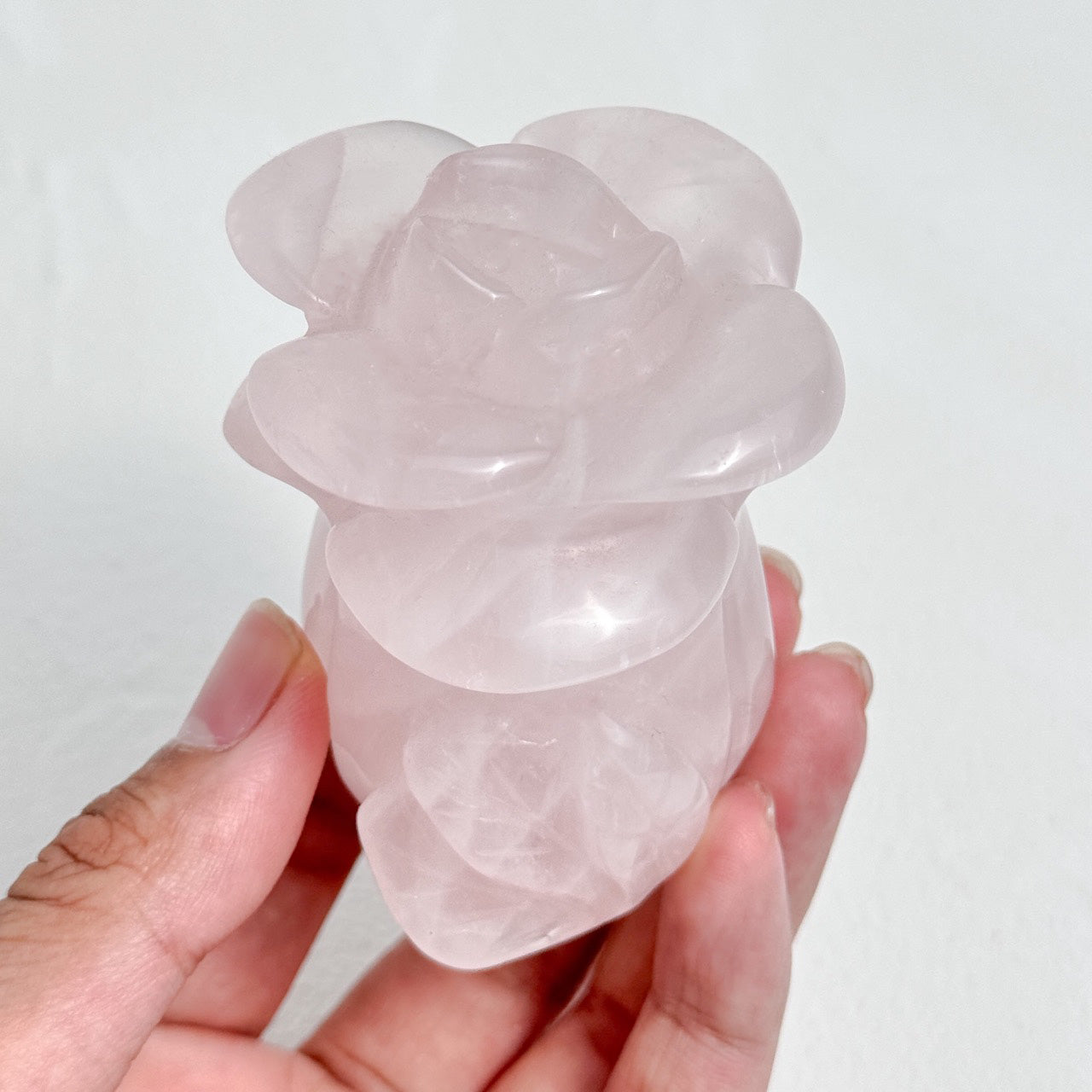 Artistic rose quartz carving with detailed petal textures.