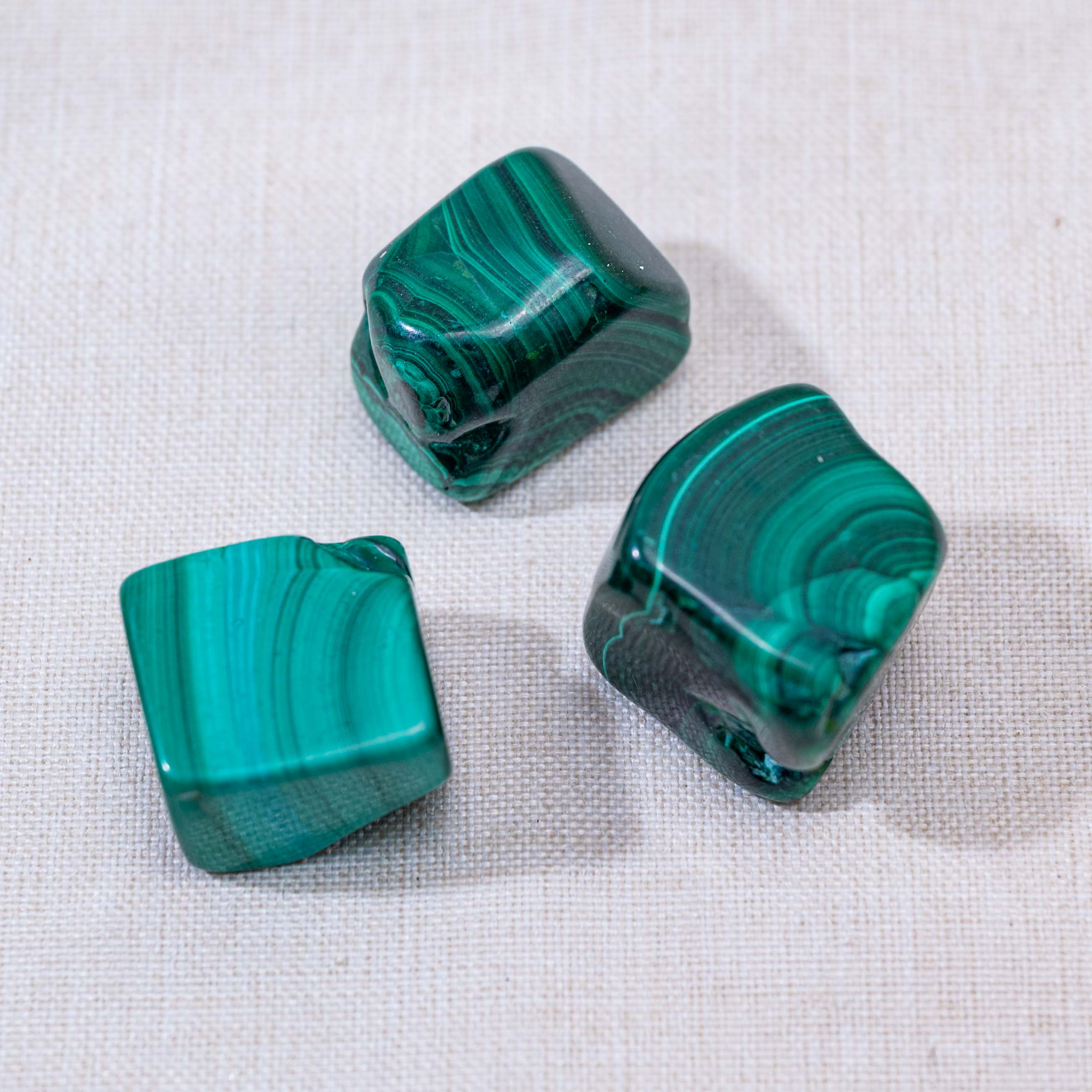 The rich green Malachite Tumbled Stone enhances positivity and protection, ideal for any collection.