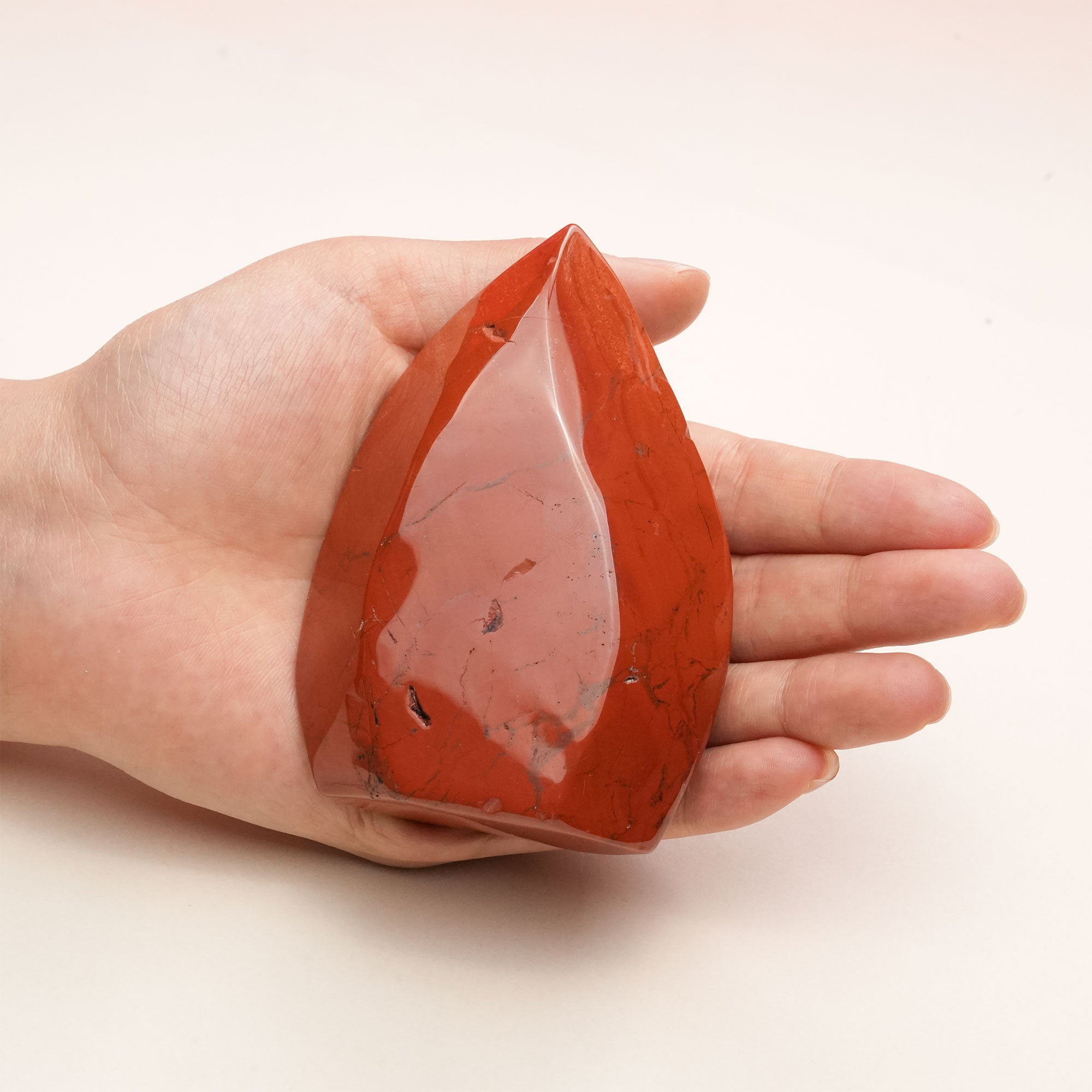 Handheld Red Jasper Freeform Crystal emphasizing its grounding energy
