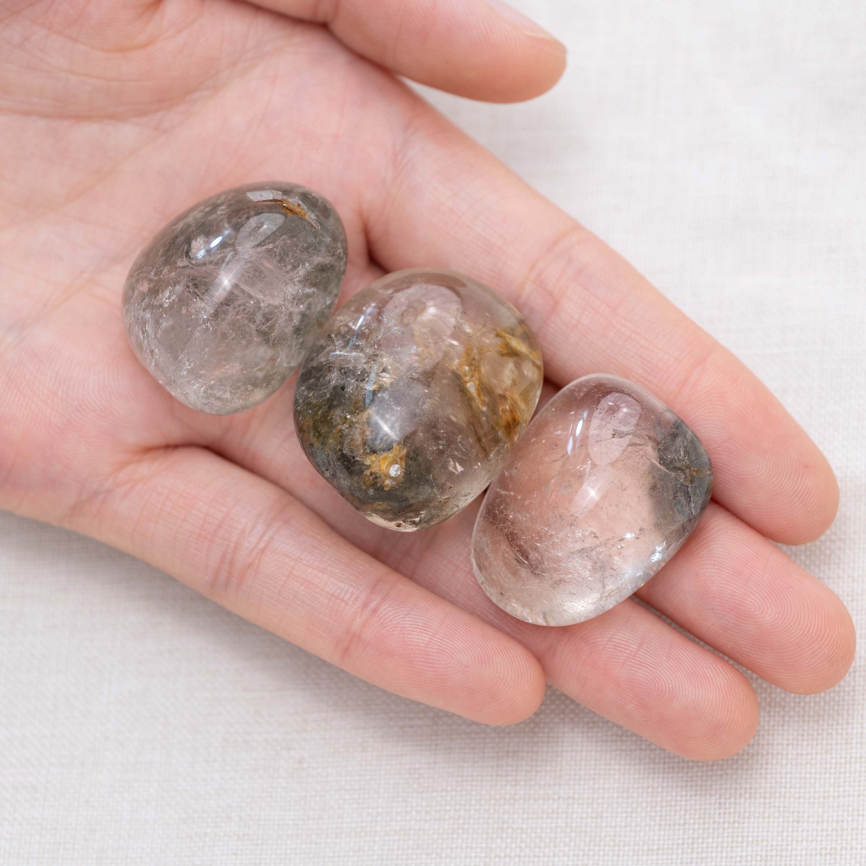 Hand cupping Phantom Quartz tumbled stone for insight
