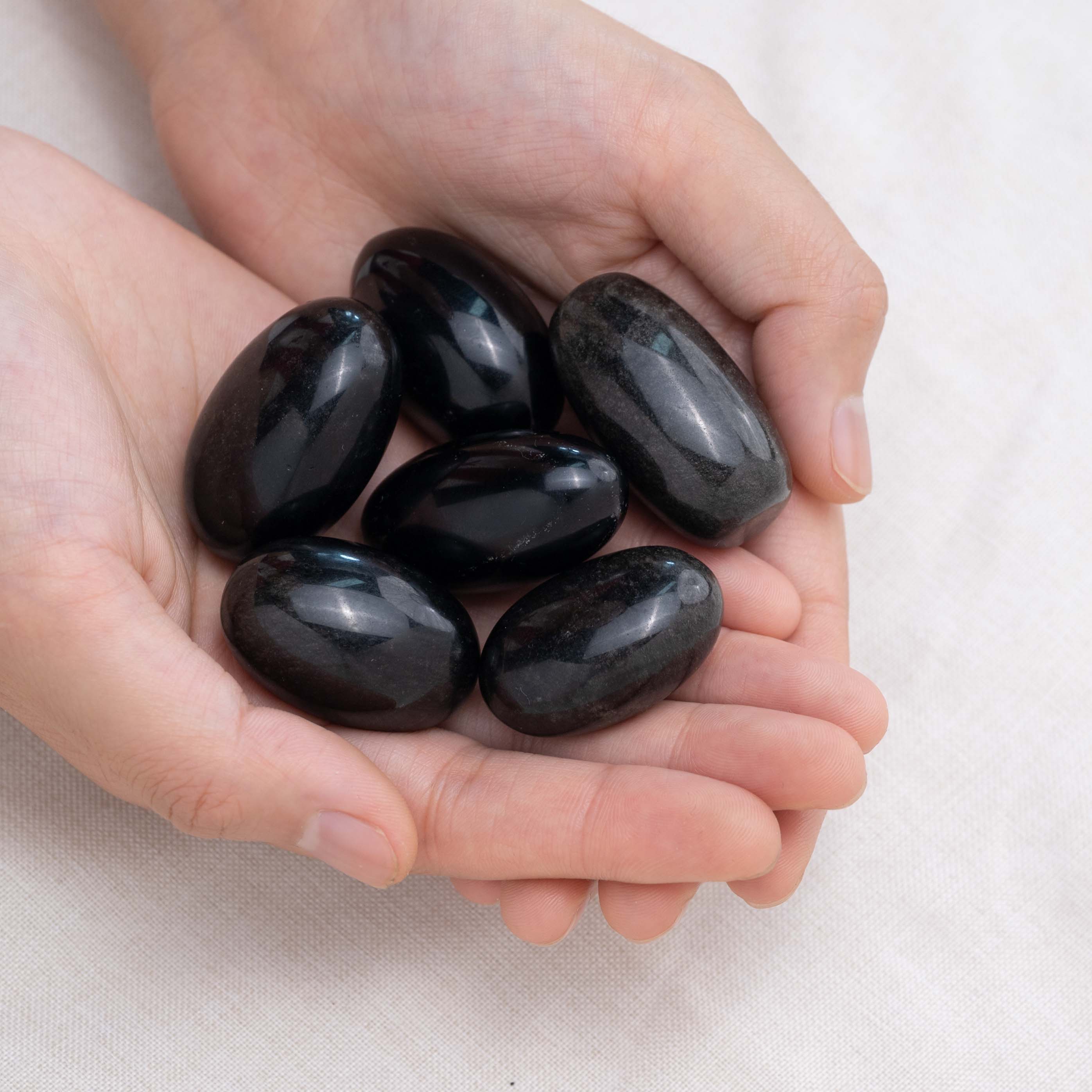Hand cupping Silver Obsidian tumbled stone for grounding