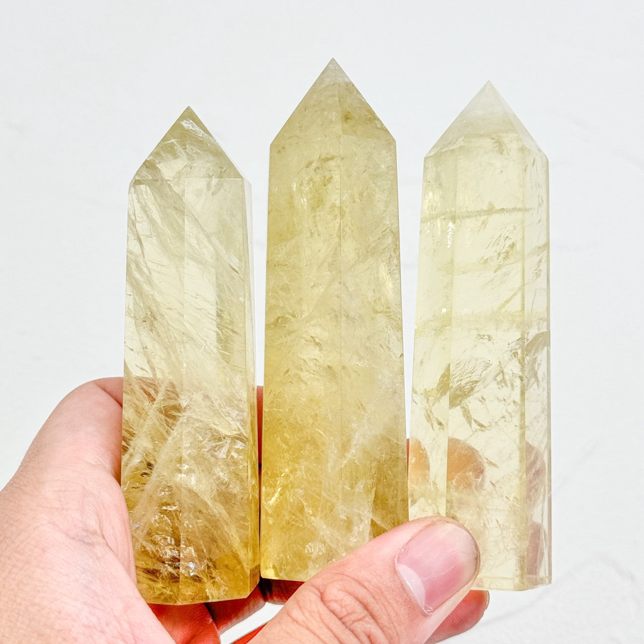 three crystal citrine points in hands
