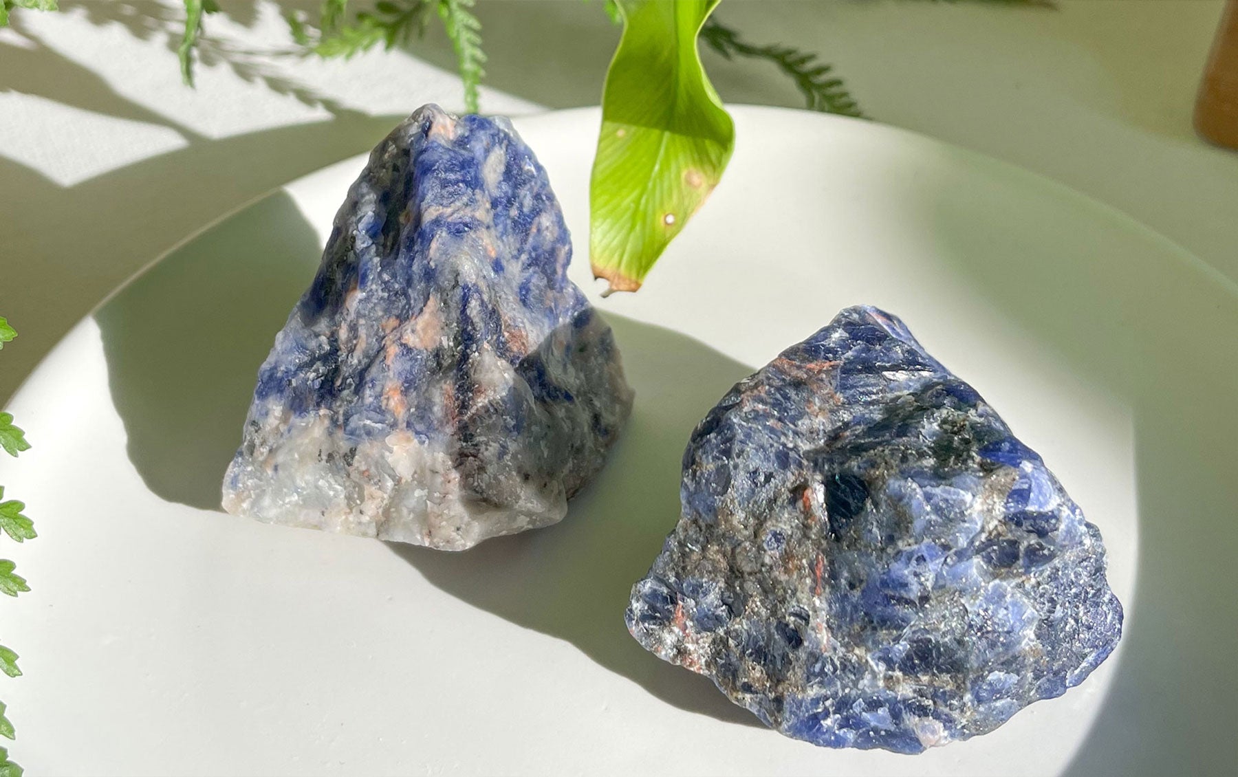 A deep blue Sodalite gemstone with white streaks and a smooth