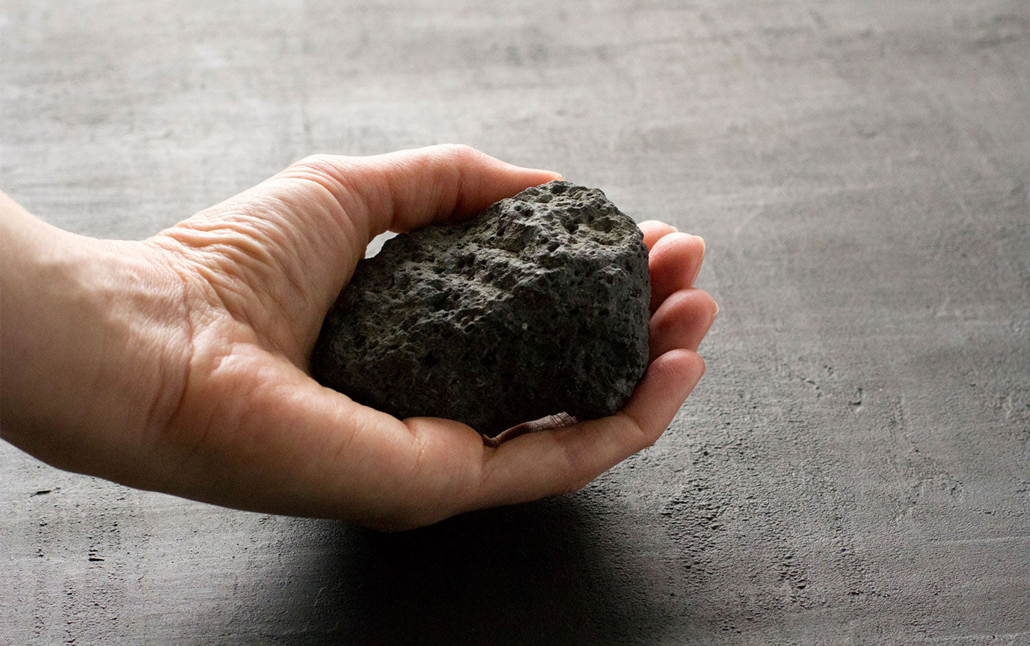 Lava stone with a porous, textured surface in deep black color