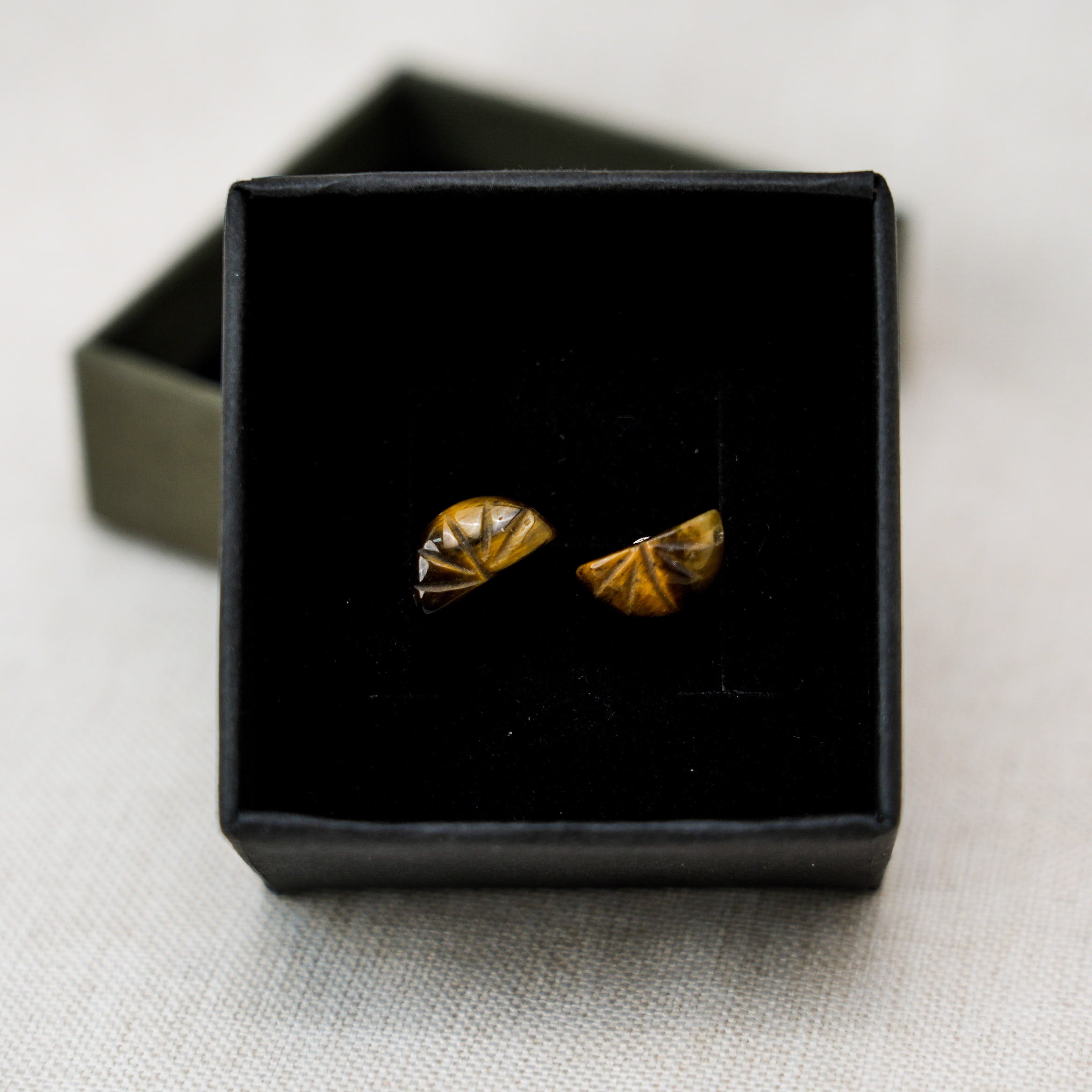 Modern and stylish tiger eye stone hoop earrings that highlight the stone's unique golden-brown hues.