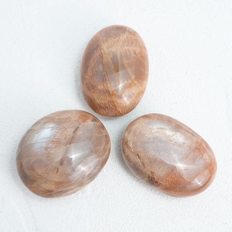 Close-up of Orange MoonStone Palm Stone, showcasing its natural beauty and soothing properties