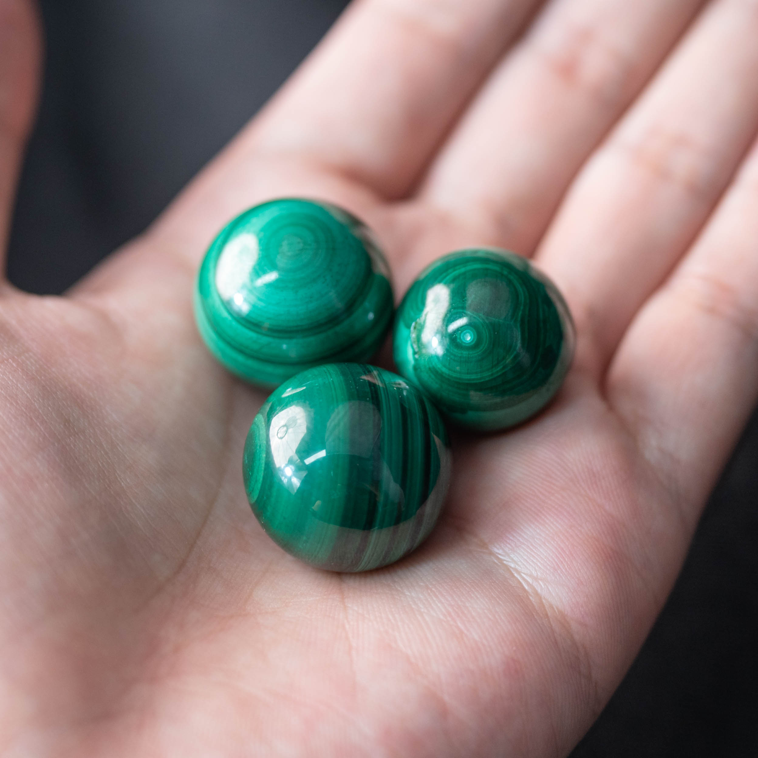 The Malachite Mini Sphere, with its unique banded patterns, serves as a beautiful talisman.