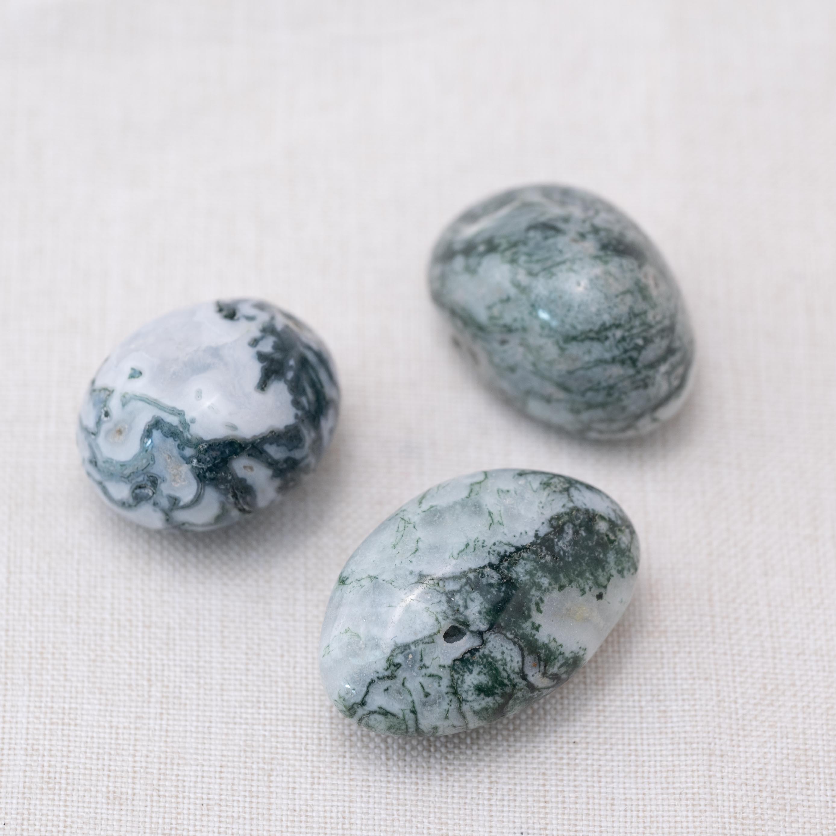 Displayed Moss Agate tumbled stones for natural energy
