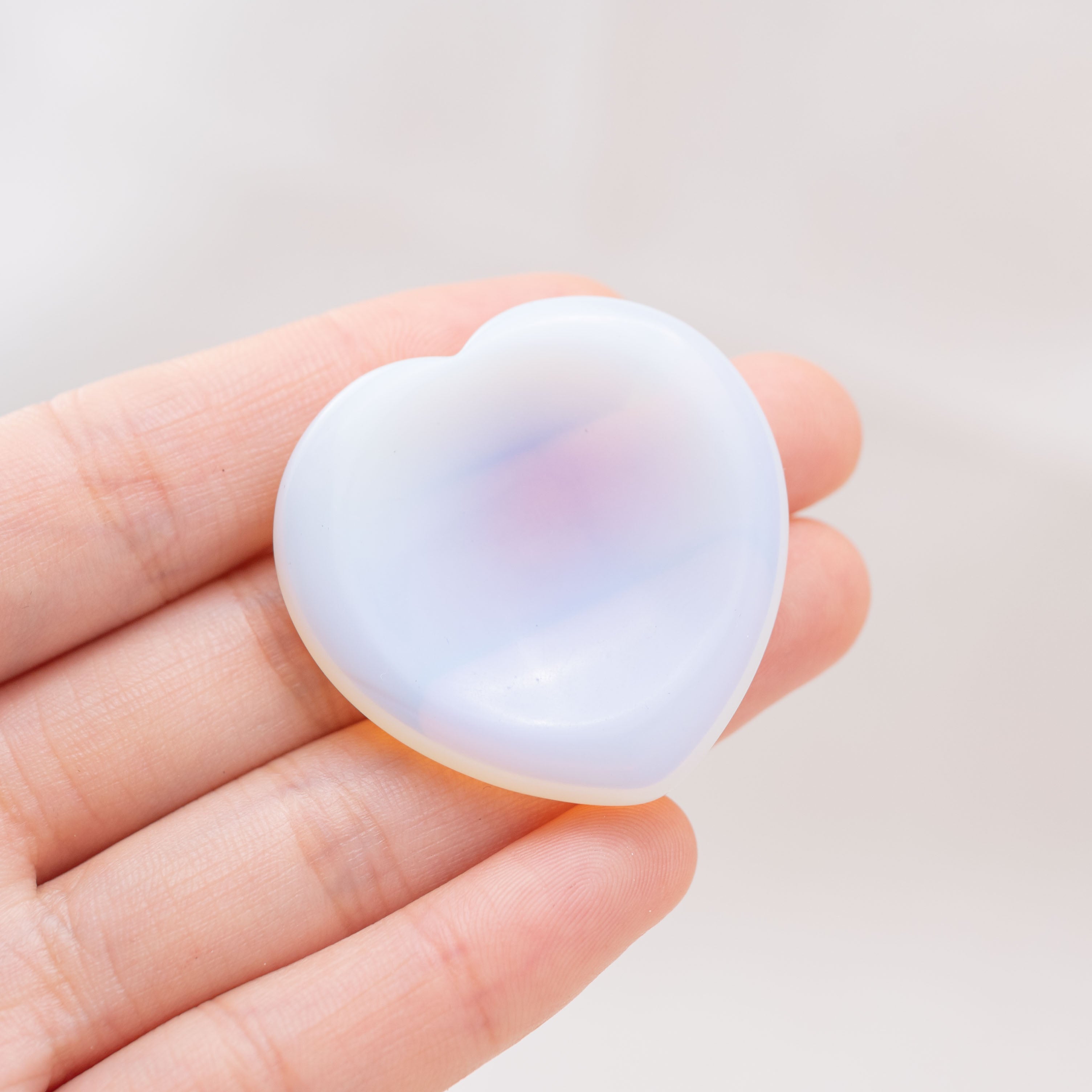 The Opalite Heart Worry Stone symbolizes clarity and transformation