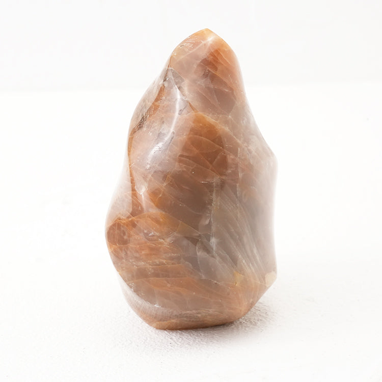 Polished Orange Moonstone Flame Crystal with lustrous sheen on a white background